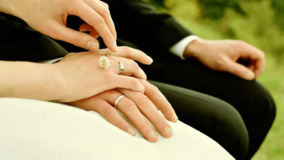 Mains d'une mariée et d'un marié avec leurs alliances